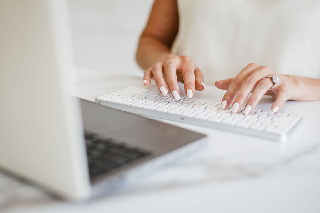 Individual typing on a computer while managing Google Ad campaigns.