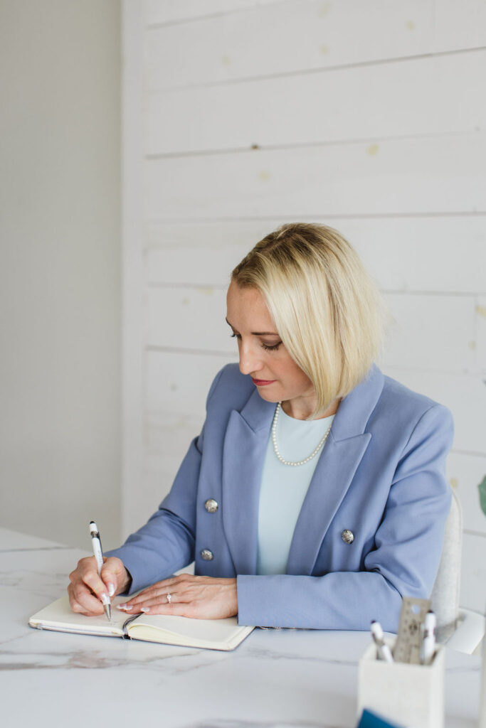 Person brainstorming creative ideas and sketching notes in a journal.