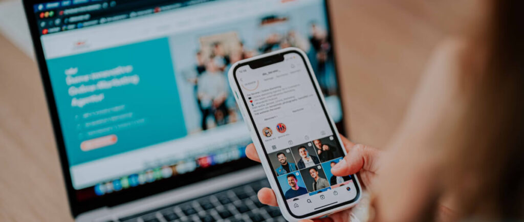 Someone scrolling on an Instagram account while also having their computer open to a website.