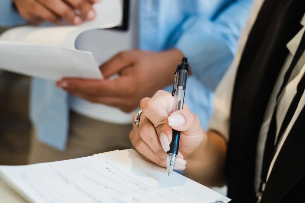 Two people taking notes while attending an event.