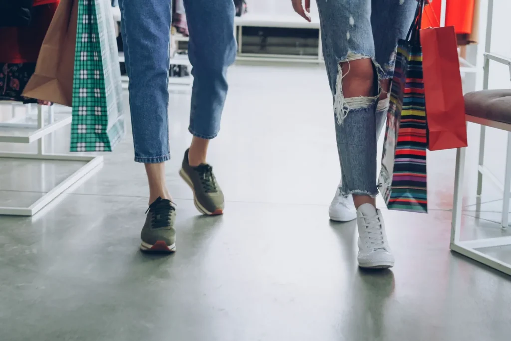 Two woman walking and carrying shopping bags.